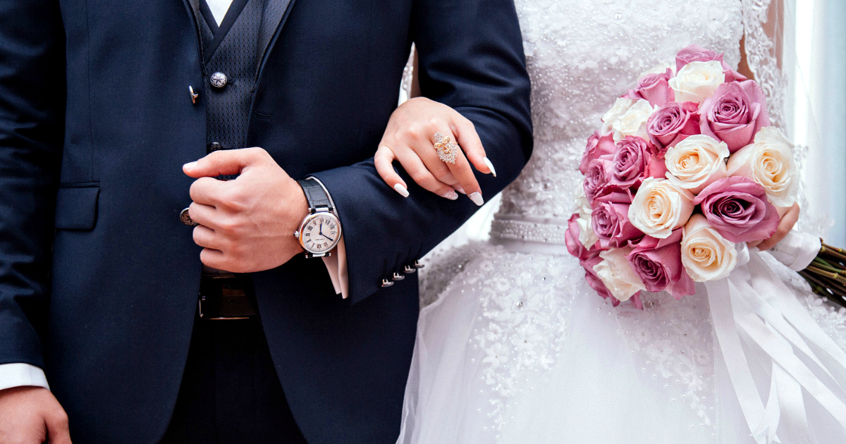 man and woman holding arms together at wedding